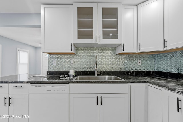 kitchen with tasteful backsplash, dark stone counters, sink, dishwasher, and white cabinetry