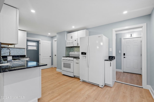 kitchen with decorative backsplash, white cabinetry, white appliances, and light wood-type flooring