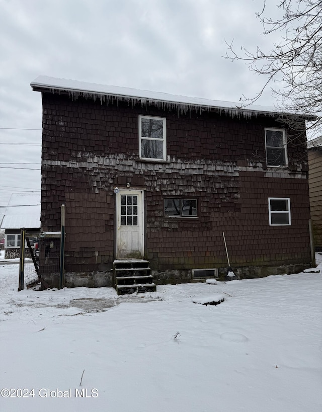 view of snow covered back of property