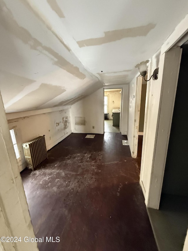 bonus room with radiator heating unit, vaulted ceiling, and washer / dryer