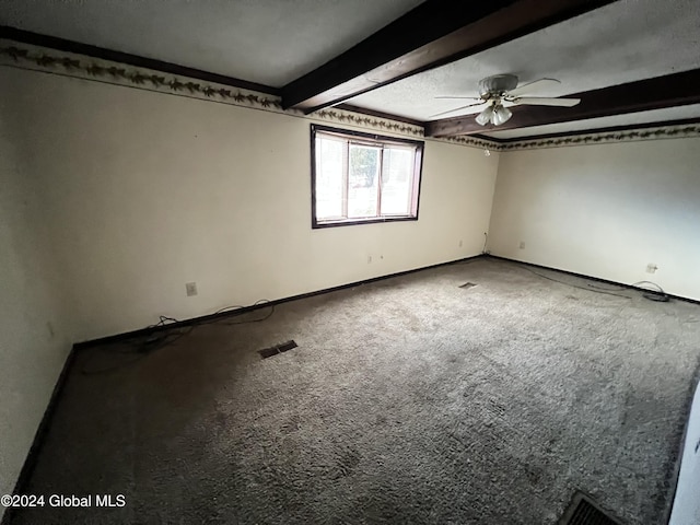 spare room with carpet flooring, ceiling fan, beamed ceiling, and a textured ceiling