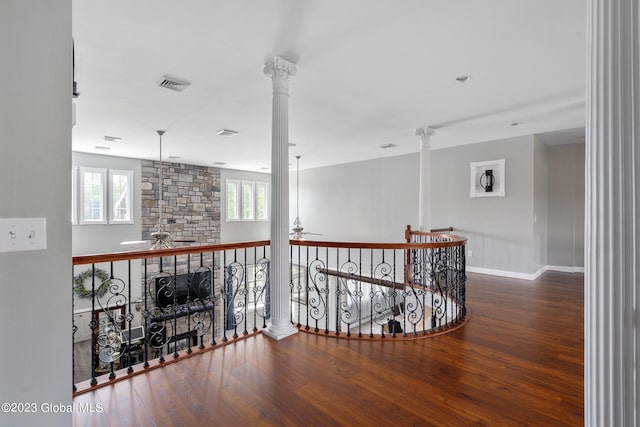 hall featuring hardwood / wood-style flooring, ornate columns, and a wealth of natural light