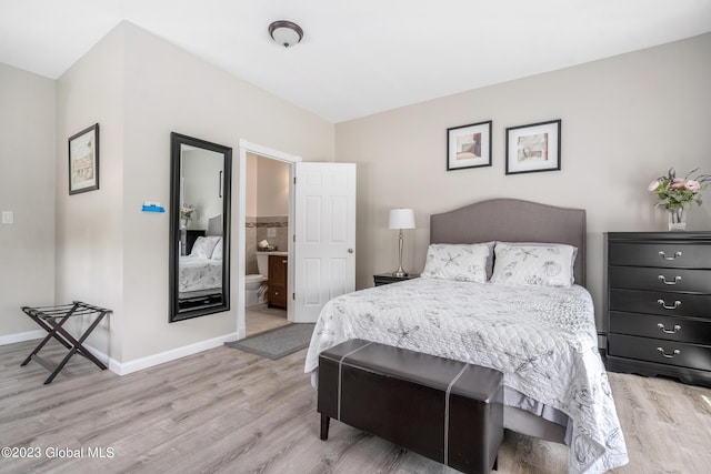 bedroom featuring light wood-type flooring and ensuite bath