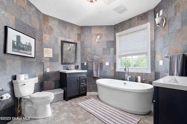 bathroom featuring vanity, toilet, tile walls, and a tub