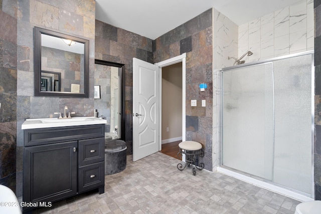 bathroom featuring vanity, walk in shower, and tile walls