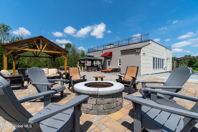 view of patio featuring a gazebo and an outdoor living space with a fire pit