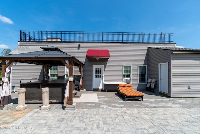 back of house with a gazebo, a hot tub, cooling unit, and a patio area