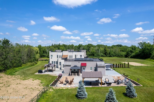 rear view of house with a gazebo, a patio area, and a jacuzzi