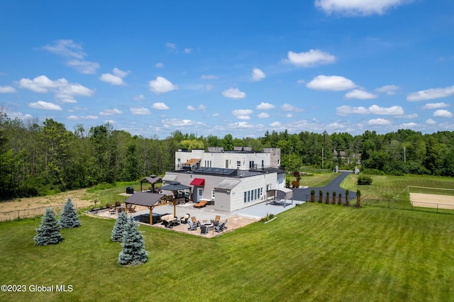 back of property featuring a gazebo, a patio area, and a lawn