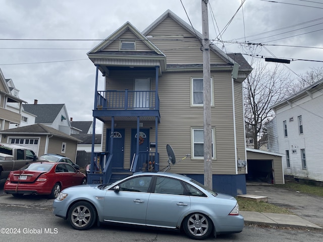 view of front of house featuring a balcony, a garage, and an outdoor structure