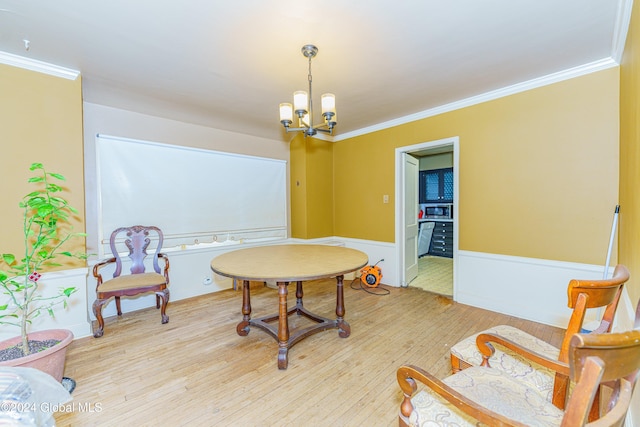 sitting room featuring light hardwood / wood-style flooring, ornamental molding, and an inviting chandelier