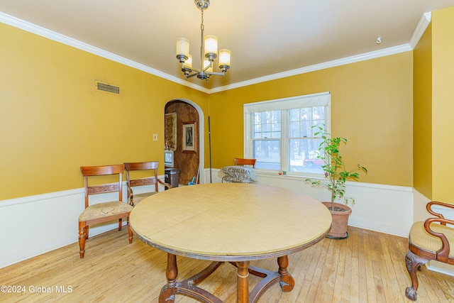 dining space with hardwood / wood-style flooring, a notable chandelier, and ornamental molding