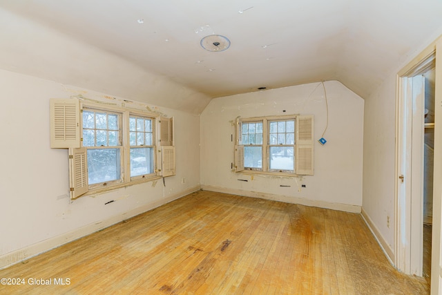 bonus room with wood-type flooring and vaulted ceiling