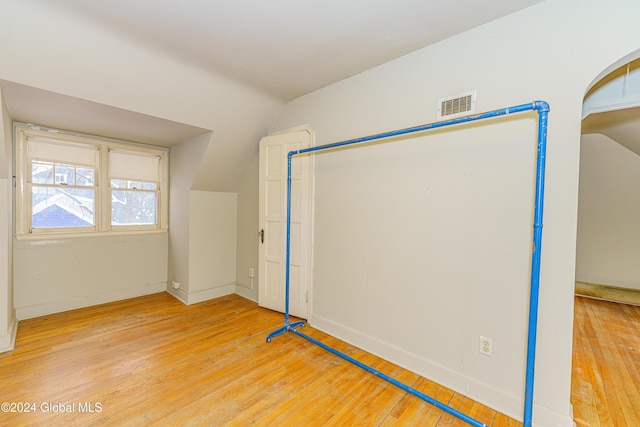 additional living space featuring light hardwood / wood-style flooring and vaulted ceiling