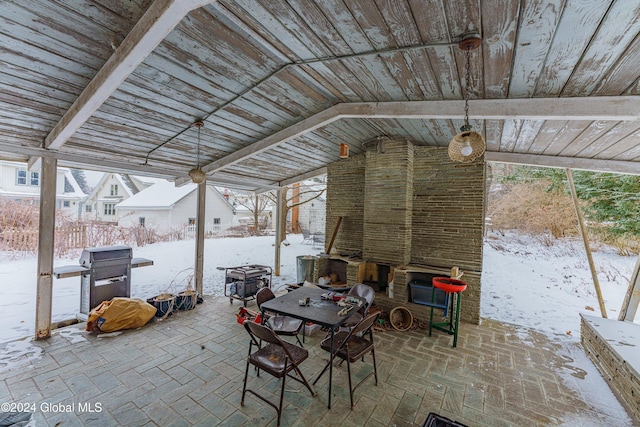 snow covered patio with a grill