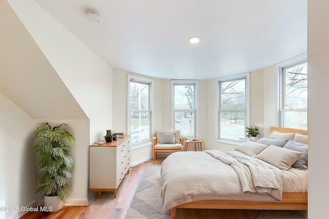 bedroom with light wood finished floors, baseboards, and recessed lighting