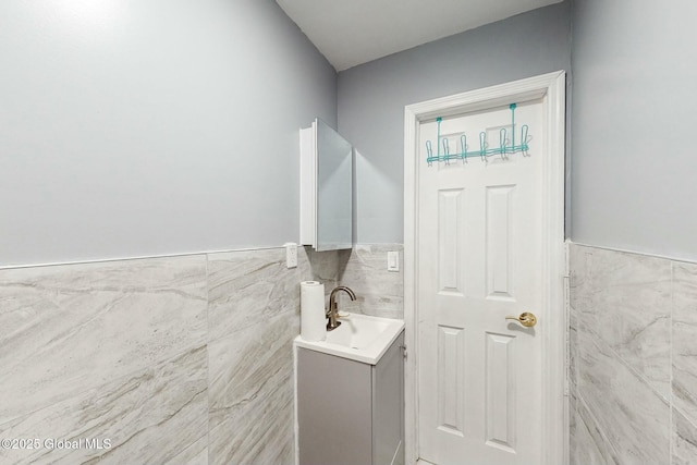 bathroom featuring vanity, tile walls, and a wainscoted wall