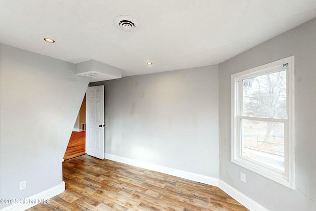 unfurnished room featuring visible vents, baseboards, recessed lighting, and wood finished floors