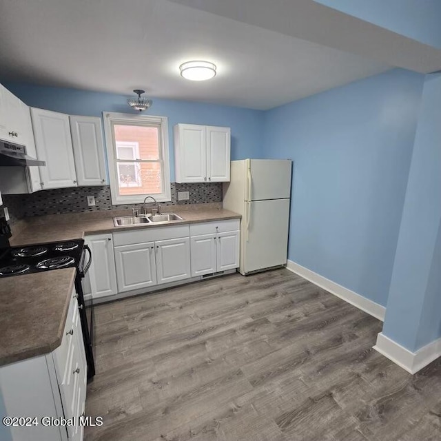 kitchen with white cabinets, white fridge, black / electric stove, and sink