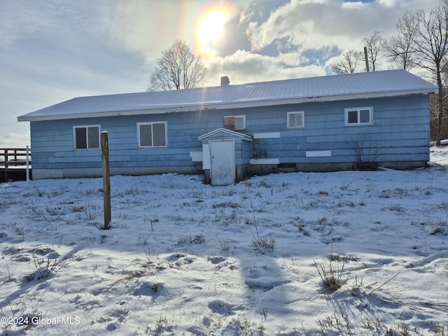 view of snow covered back of property