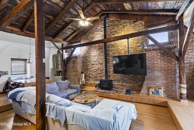 living room featuring a wood stove, wood-type flooring, beam ceiling, and wood ceiling