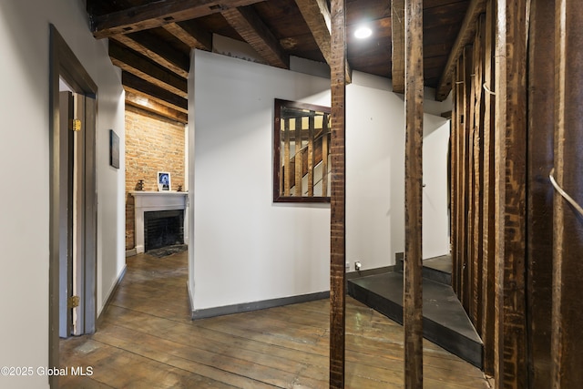 hall with beam ceiling, dark hardwood / wood-style floors, and wooden ceiling