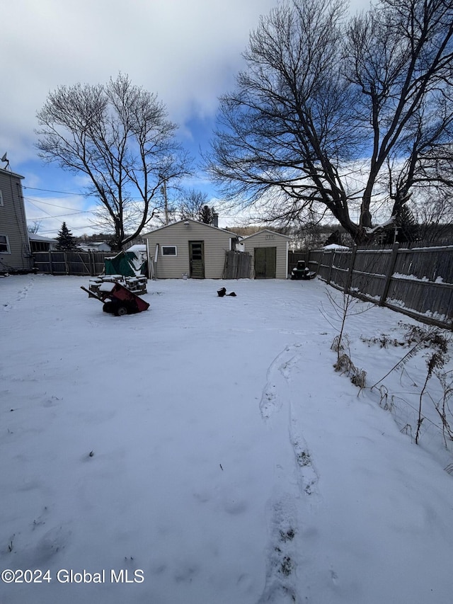 snowy yard featuring an outdoor structure