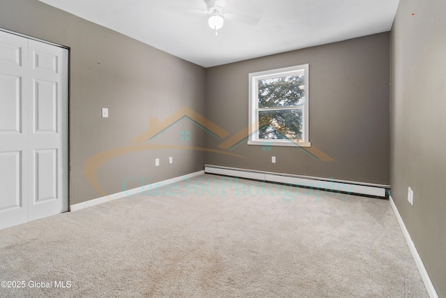 spare room with carpet floors, a baseboard radiator, and ceiling fan