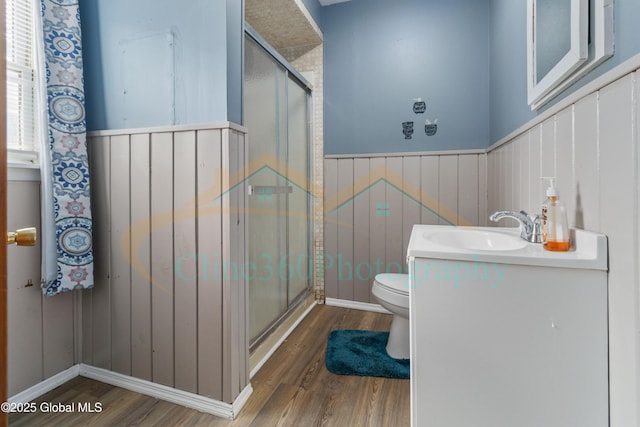 bathroom featuring hardwood / wood-style flooring, vanity, and a shower with shower door