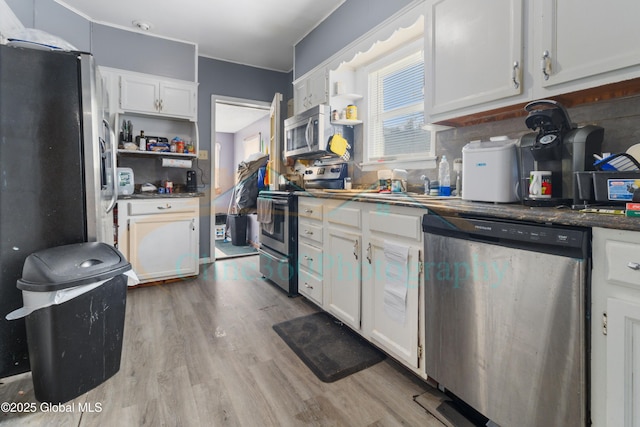 kitchen featuring white cabinets, light wood-type flooring, and appliances with stainless steel finishes