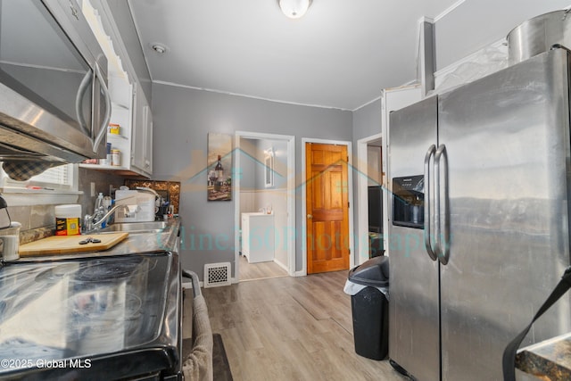 kitchen featuring sink, light wood-type flooring, and appliances with stainless steel finishes