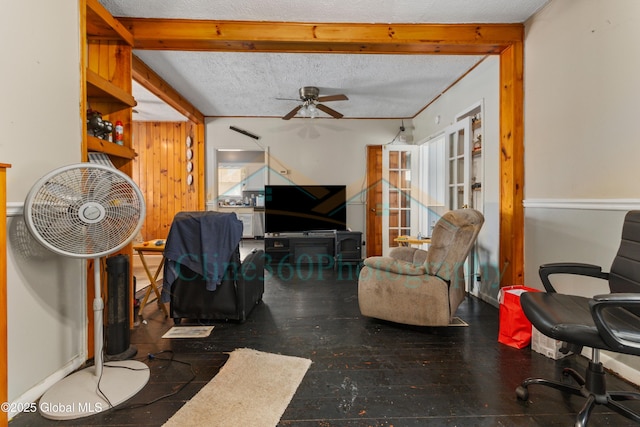 living room with ceiling fan, beam ceiling, and a textured ceiling