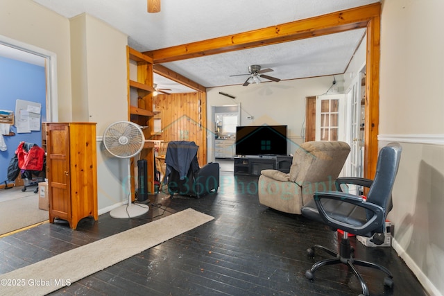 living room with beam ceiling, a textured ceiling, ceiling fan, and dark wood-type flooring