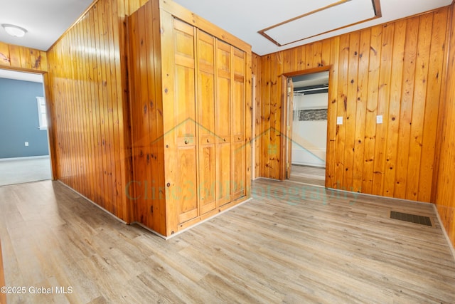 hall with wood walls and light wood-type flooring