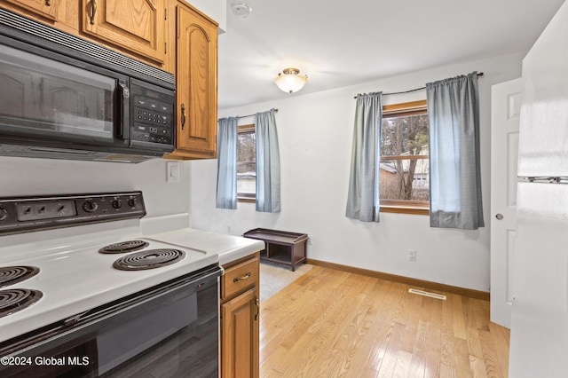 kitchen featuring white range with electric cooktop and light hardwood / wood-style flooring