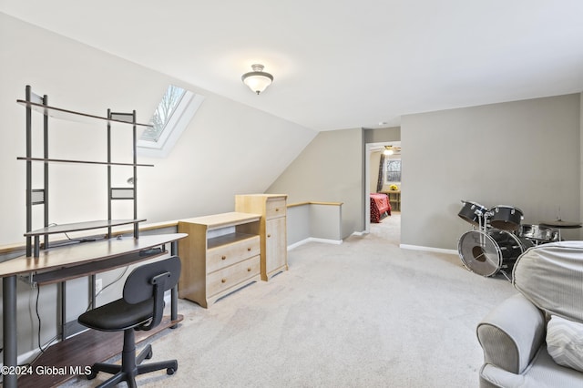 office with vaulted ceiling with skylight and light colored carpet