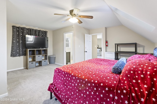 carpeted bedroom featuring ceiling fan, lofted ceiling, and ensuite bath