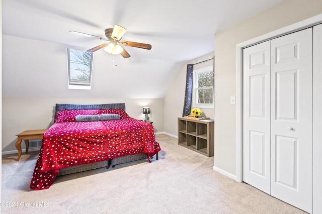 carpeted bedroom with ceiling fan, a closet, and lofted ceiling