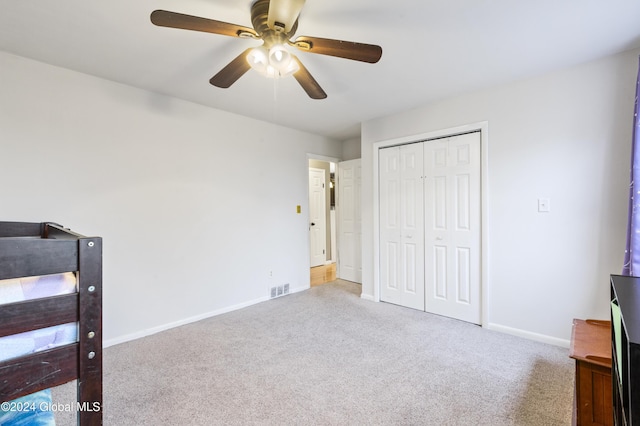 unfurnished bedroom with carpet flooring, ceiling fan, and a closet