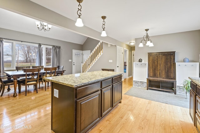 kitchen with decorative light fixtures, a center island, a chandelier, and light hardwood / wood-style flooring