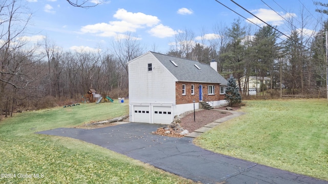 view of side of home featuring a lawn, a playground, and a garage