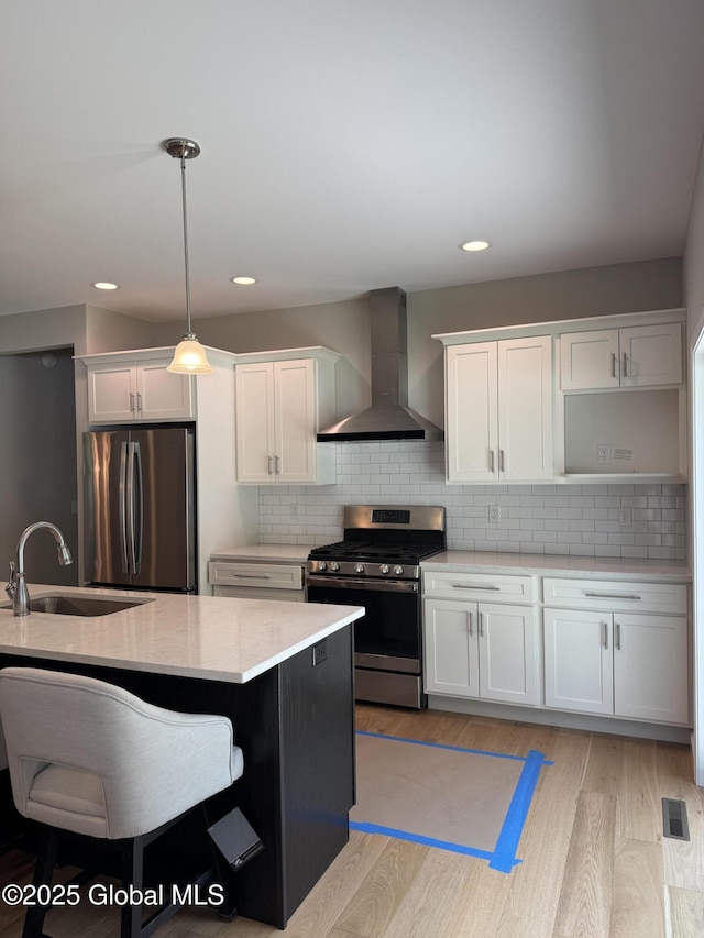 176 Butler Rd, Moreau, NY 12828 - kitchen featuring stainless steel appliances, wall chimney exhaust hood, a sink, white cabinetry, and recessed lighting