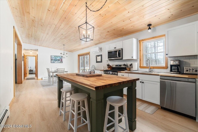 kitchen featuring wood counters, white cabinets, appliances with stainless steel finishes, decorative light fixtures, and wood ceiling