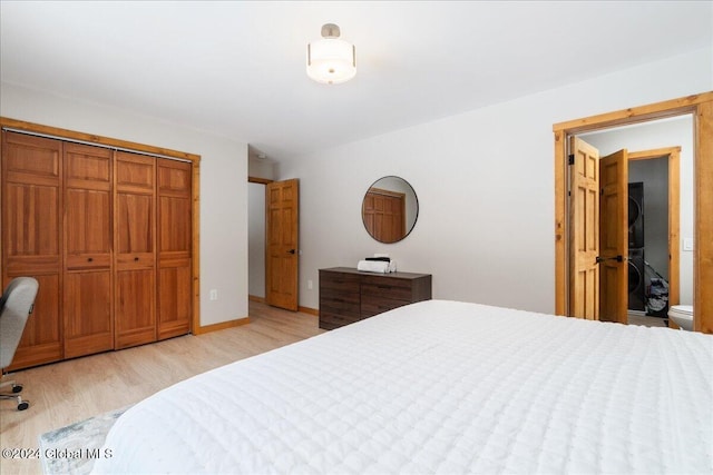 bedroom with ensuite bathroom, a closet, and light hardwood / wood-style flooring