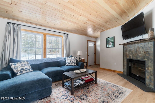 living room featuring a tile fireplace, light wood-type flooring, and wood ceiling