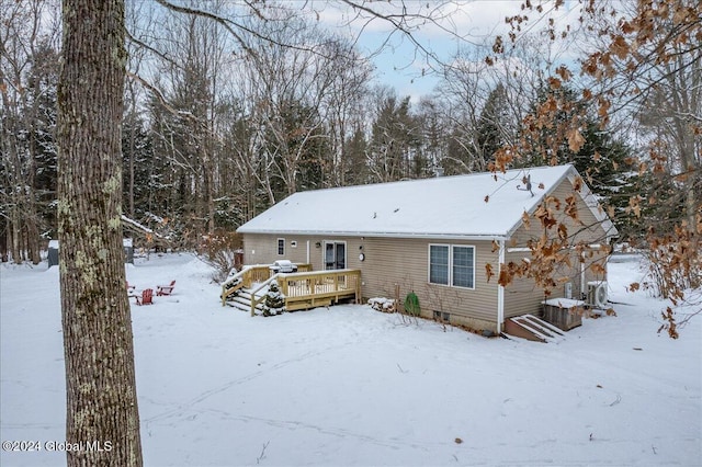 snow covered back of property featuring a wooden deck