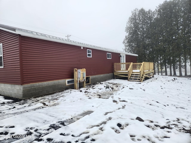 snow covered property featuring a wooden deck