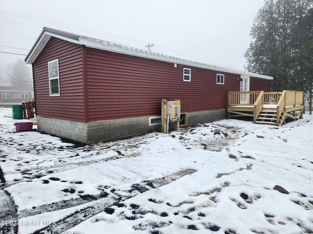 view of snow covered exterior with a deck