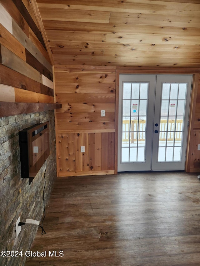 unfurnished living room with french doors, lofted ceiling, wooden walls, and wooden ceiling