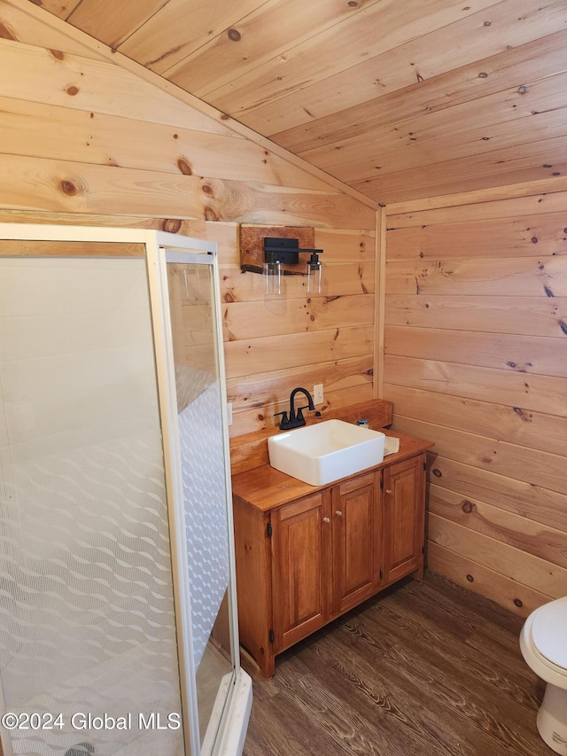 bathroom featuring wood walls, wood-type flooring, vaulted ceiling, toilet, and wood ceiling